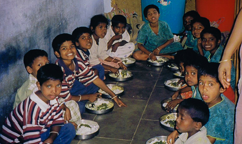 Die Kinder essen zusammen Mittag im Heim